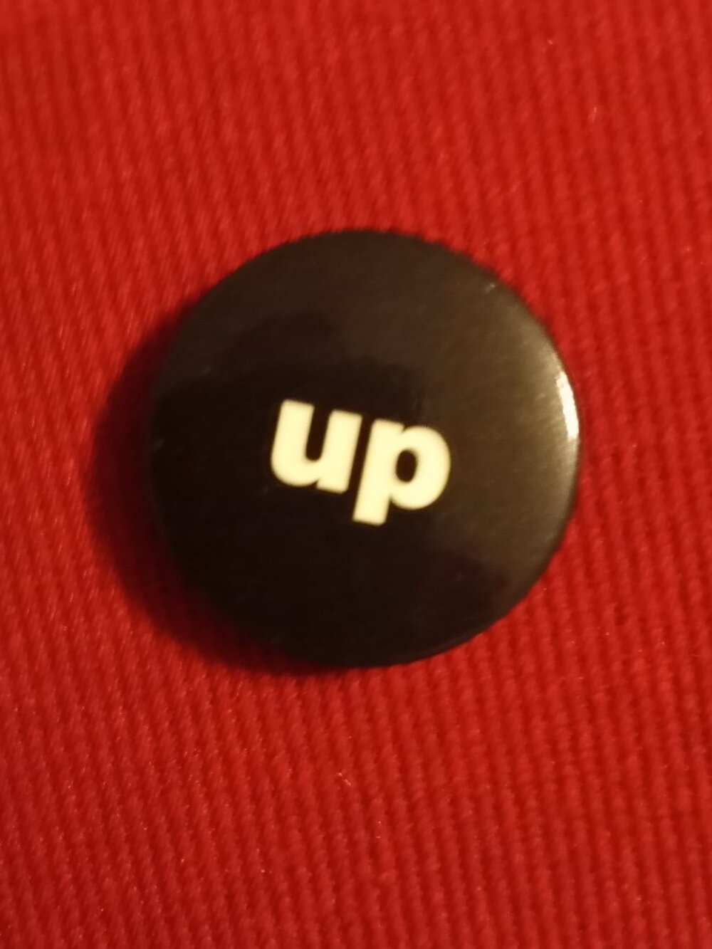 black and white "up" button pin